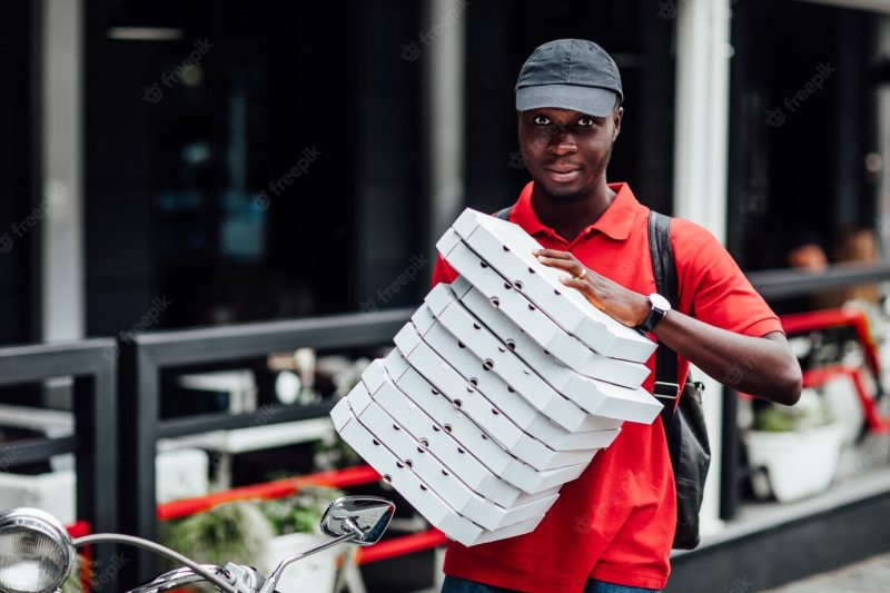 Impatient pizza delivery driver poses on fast motorbike Free Photo