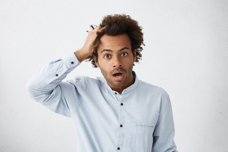 Indoor shot of unshaven dark-skinned office worker in formal shirt Free Photo