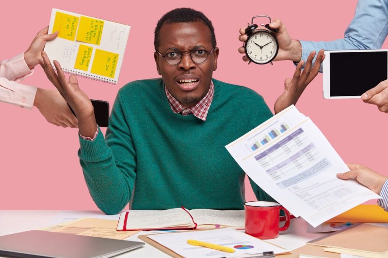 Irritated overworked overload african american guy raises hands with anger, being angry with colleagues who remind him about work Free Photo