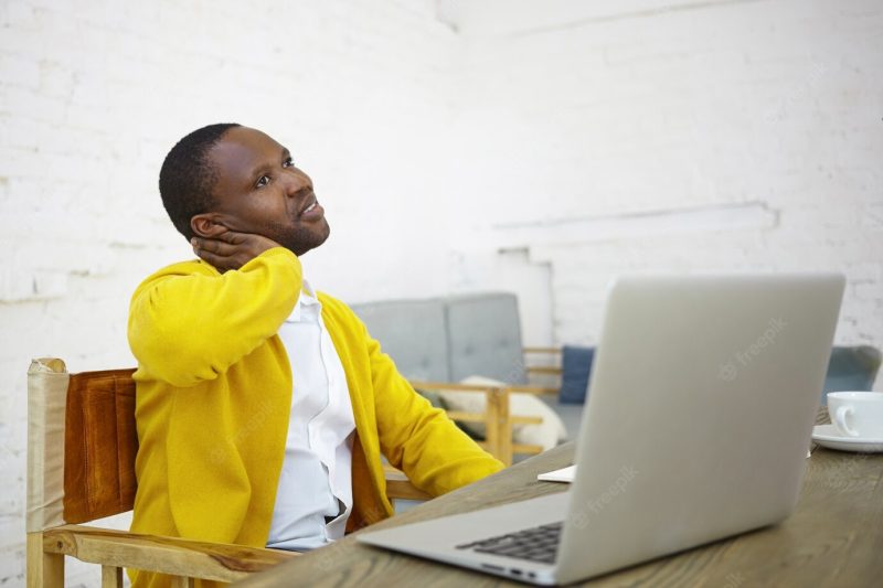 Job, creativity, occupation and freelance concept. portrait of stylish prosperous dark skinned male entrepreneur sitting in front of open laptop at desk working on start up project having pensive look Free Photo