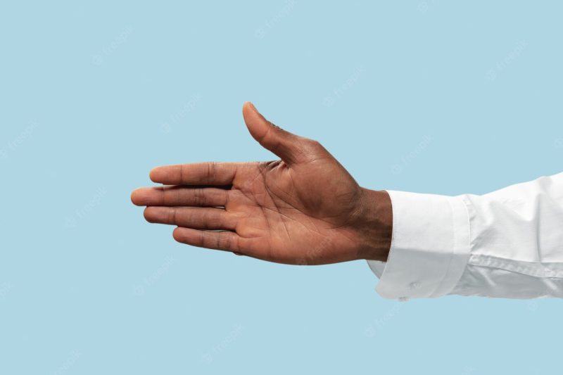 Male hand in white shirt demonstrating a gesture of inviting or pointing isolated on blue. Free Photo