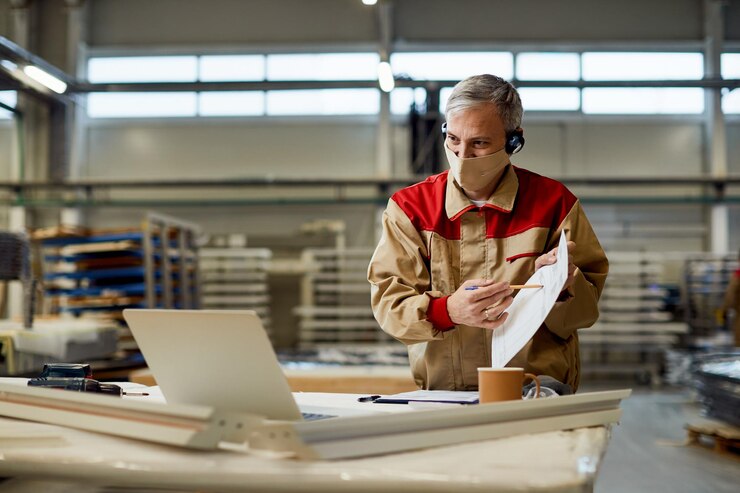 Manual Worker With Face Mask Talking About Business Reports During Video Call Carpentry Workshop 637285 11707