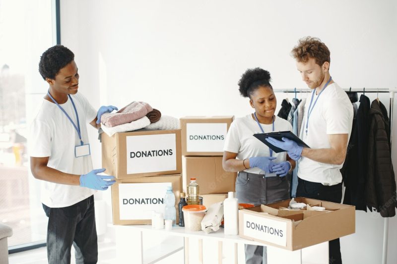 Men packing a box. African girl volunteer. humanitarian aid to people. Free Photo