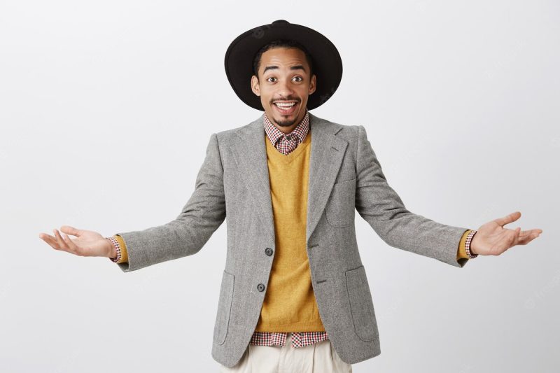 Miracles can happen. portrait of pleased friendly African-American male student in stylish outfit, spreading hands and smiling broadly, happy while showing lots of opportunities Free Photo