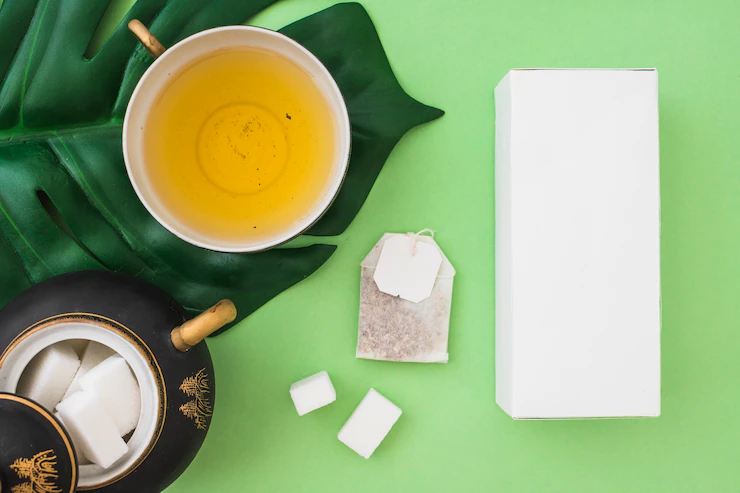 Overhead View Herbal Tea Cup With Sugar Cubes Tea Bag Box Green Background 23 2147874131