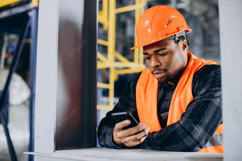 Portrait of african american man talking on the phone at a factory Free Photo