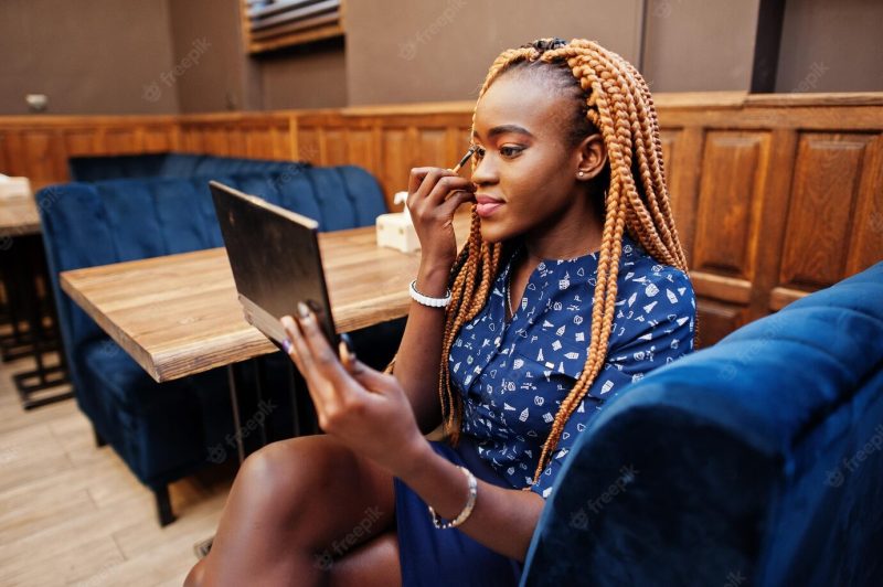 Portrait of beautiful young african business woman wearing blue blouse and skirt holding make up palette and prepare Free Photo