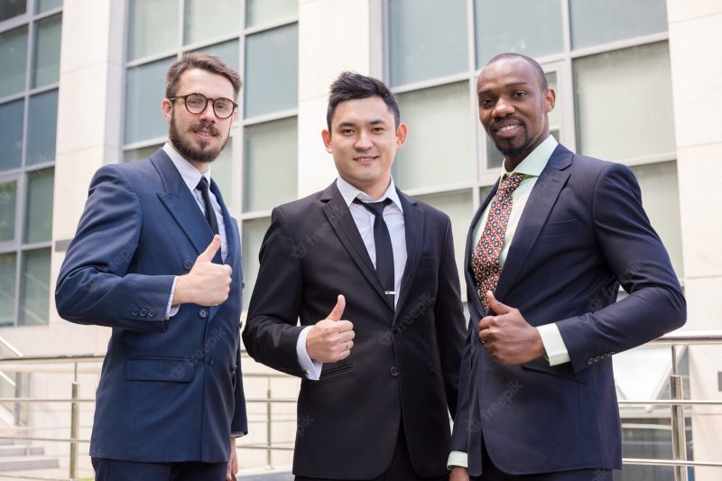 Portrait of business team holding their thumbs up Free Photo