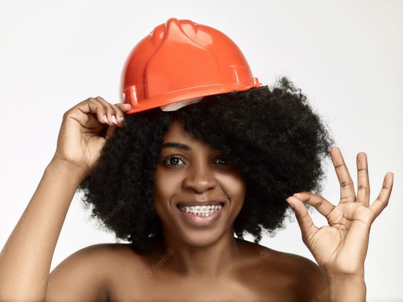 Portrait of confident female worker in orange helmet Free Photo