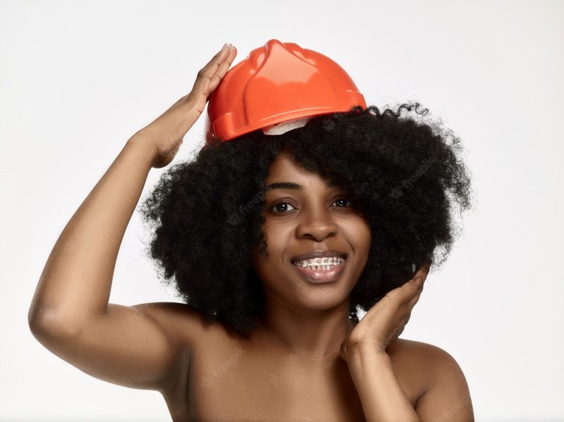 Portrait of confident female worker in orange helmet Free Photo