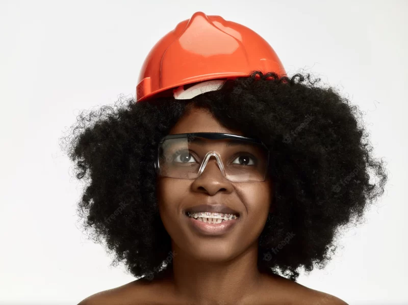 Portrait of confident female worker in orange helmet Free Photo