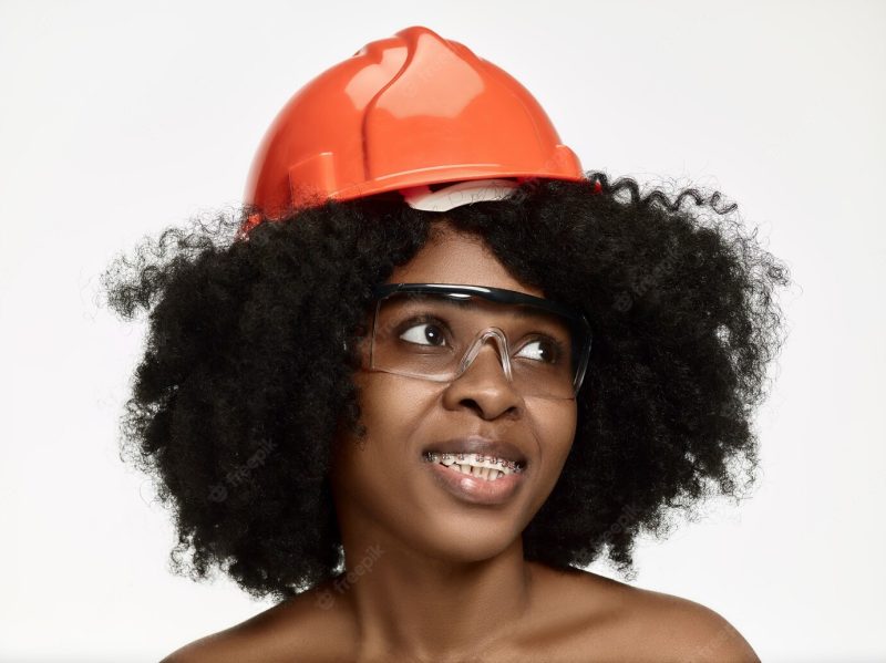 Portrait of confident female worker in orange helmet Free Photo