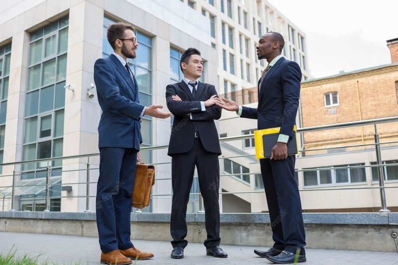 Portrait of multi ethnic business team.three smiling men standing against the background of city. the one man is european, other is Chinese and African-American. Free Photo