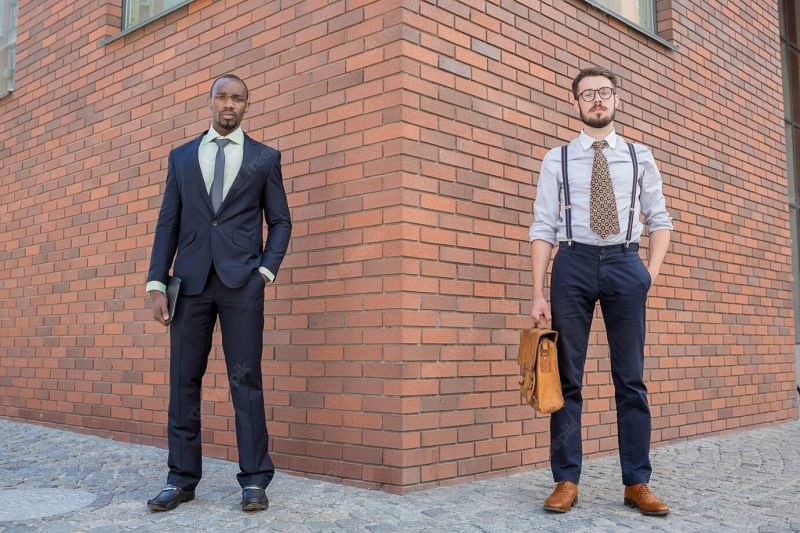 Portrait of multi ethnic business team. two men standing against the backdrop of the city. the one man is african-american, other is European. concept of business success Free Photo