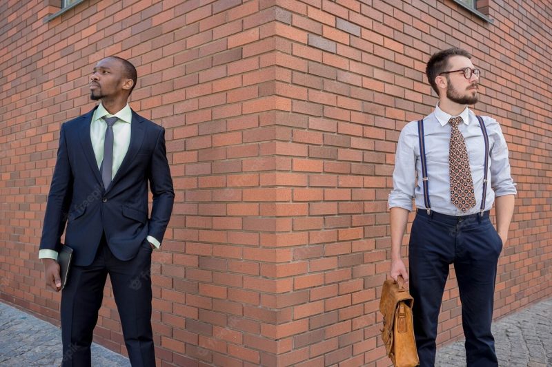 Portrait of multi ethnic business team. two men standing against the backdrop of the city. the one man is african-american, other is European. concept of business success Free Photo