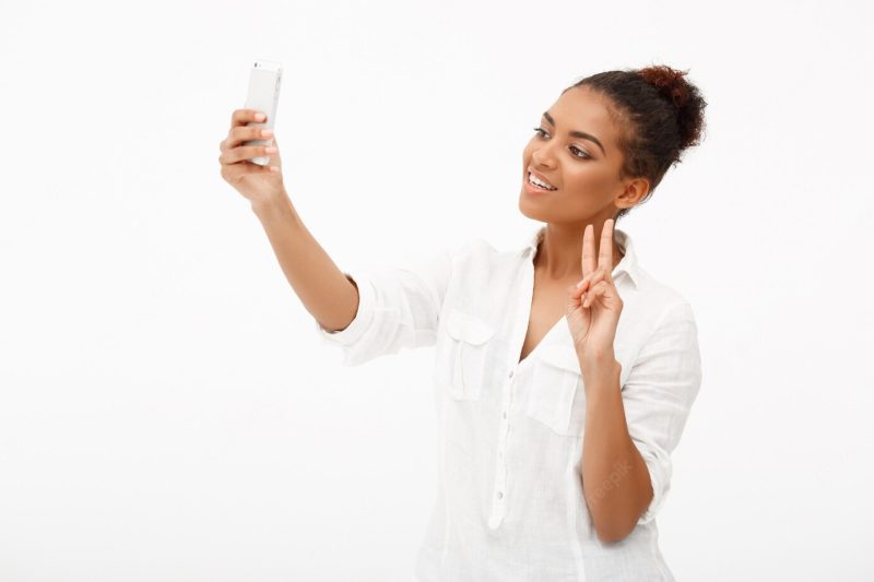 Portrait of young African woman making selfie on white background Free Photo