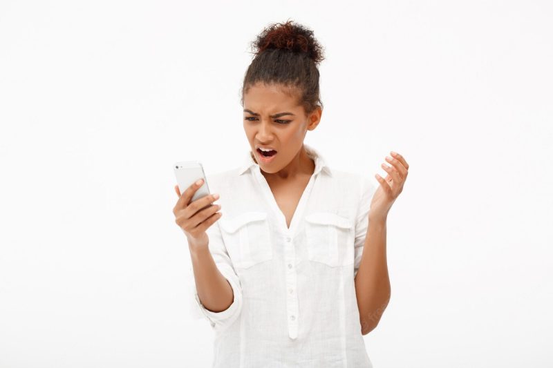 Portrait of young African woman with phone on white. Free Photo