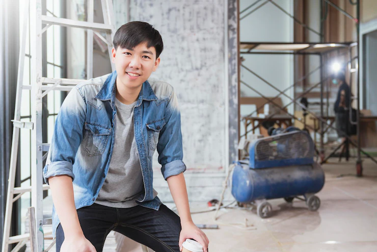 Portrait of young asian contractor carpenter smile with confident at home renovate site construction background Free Photo