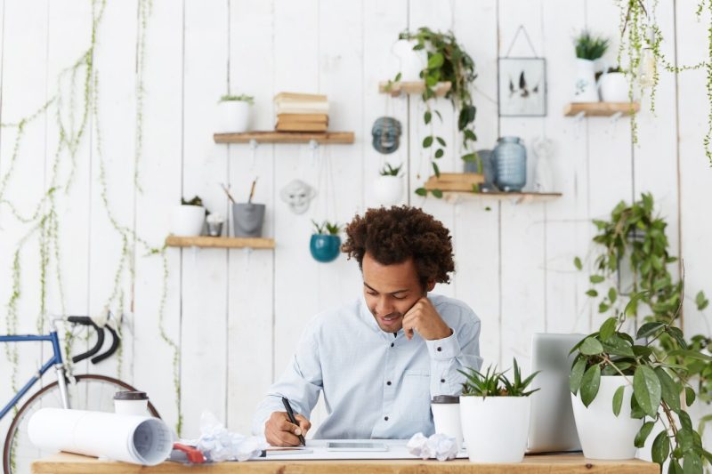 Professional dark-skinned architect male with African hairstyle dressed in formal white shirt Free Photo