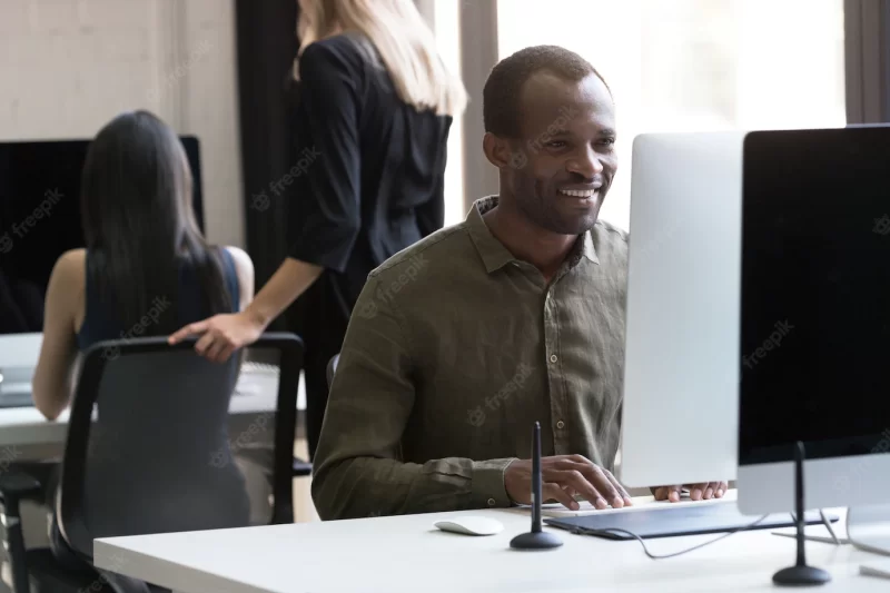 Smiling african american businessman working on his computer Free Photo