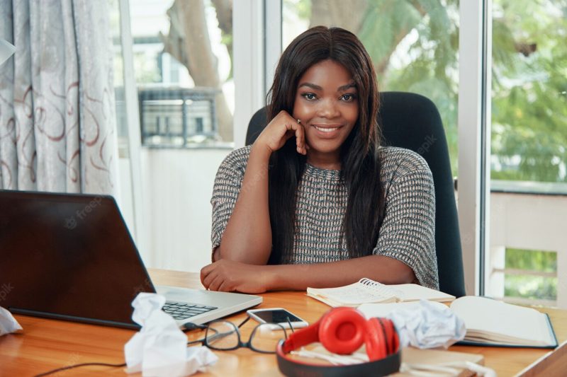 Smiling ethnic businesswoman at working table Free Photo