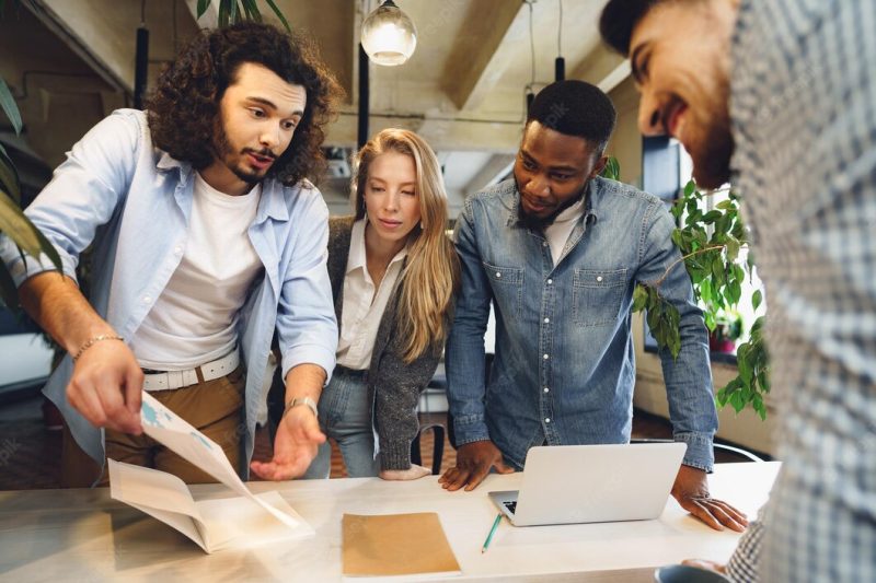 Smiling multiracial coworkers working together at office meeting have a discussion Free Photo