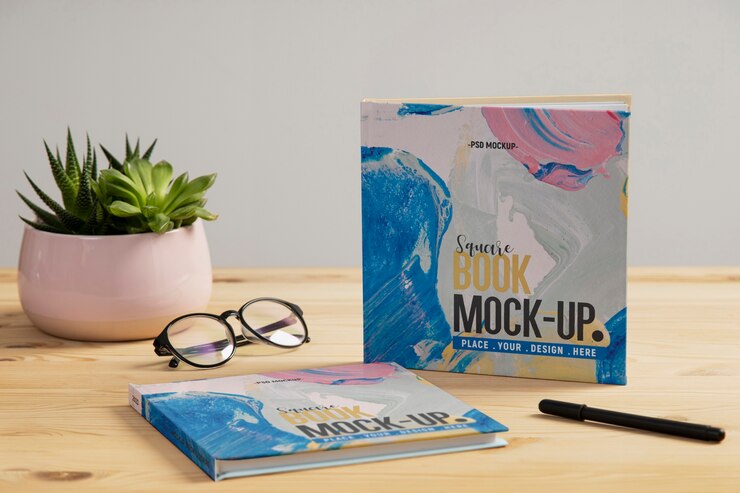 Square book mock-up on wooden office desk Free Psd