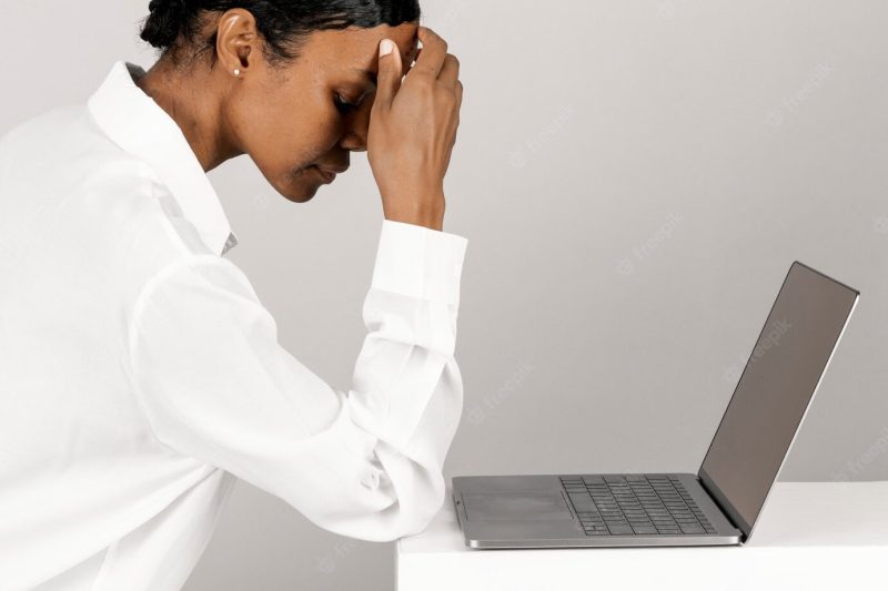 Stressed black woman using a laptop Free Photo