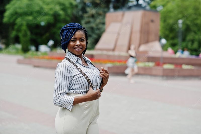 Stylish african american business woman at trousers with suspender and blouse posed outdoor Free Photo