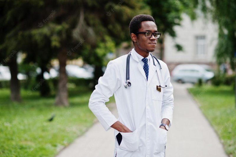 Stylish african american doctor with stethoscope and lab coat at glasses posed outdoor Free Photo