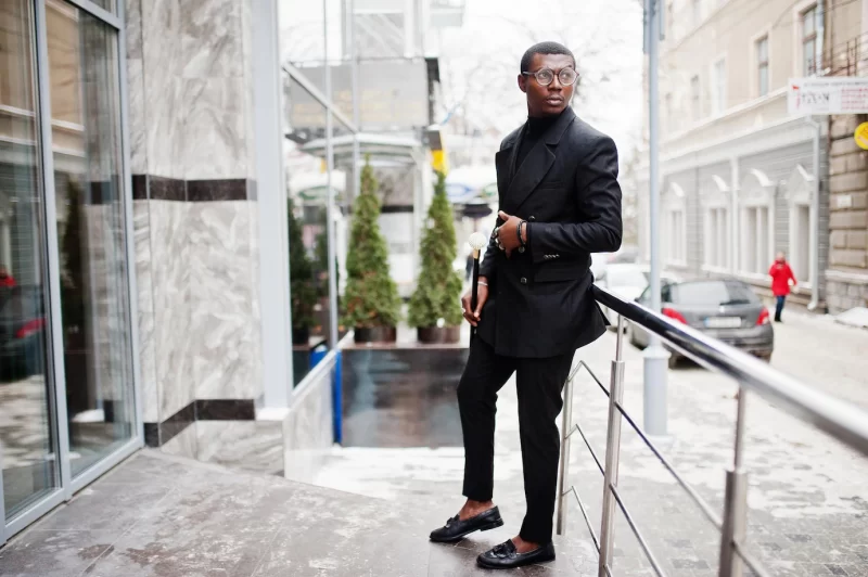 Stylish african american gentleman in elegant black jacket holding retro walking stick as cane flask or tippling cane with golden diamond ball handle rich fashionable afro man Free Photo