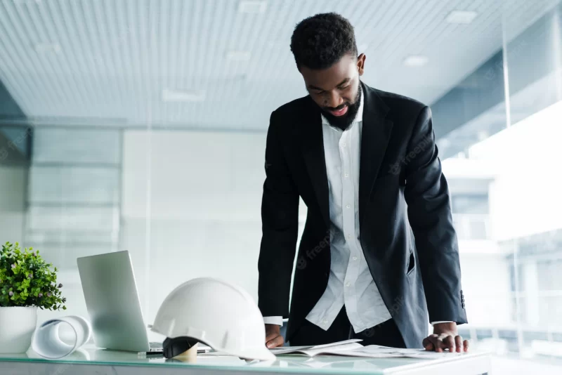 Successful businessman. handsome young African man e standing in creative office Free Photo