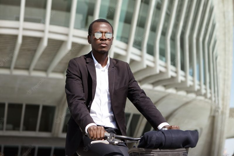 Successful ecologically conscious young afro american entrepreneur preferring bicycle to get to office instead of picking transport or car that polluting air while concerned about environment Free Photo