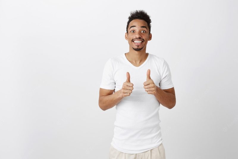 Supportive handsome African American man showing thumbs-up in approval, like idea, praise good choice Free Photo