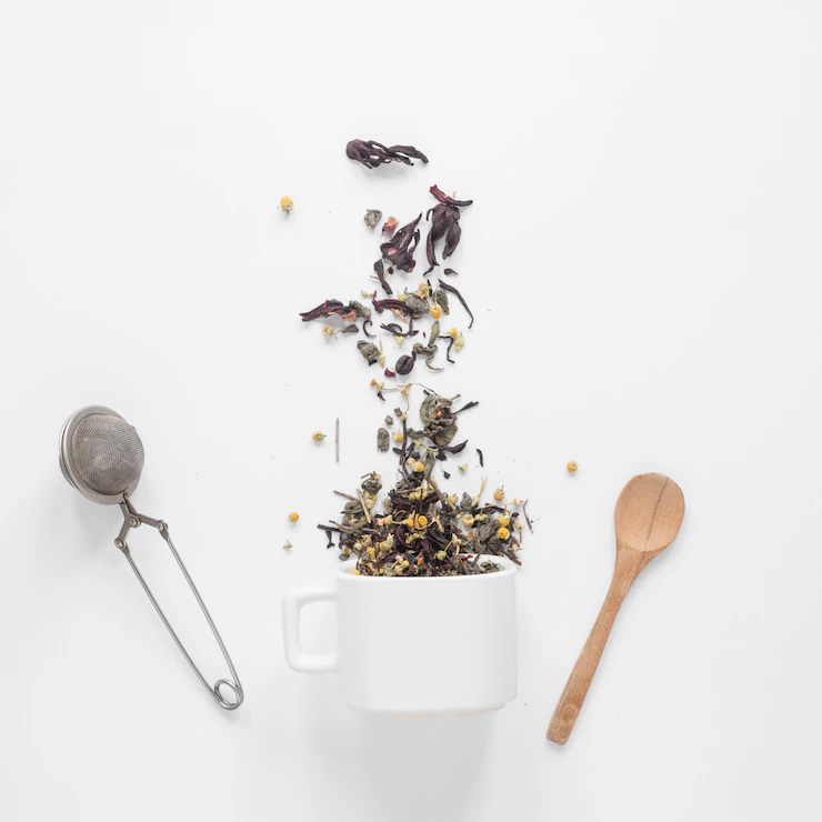 Tea Herbs Falling From Cup With Strainer Spoon White Backdrop 23 2148028192