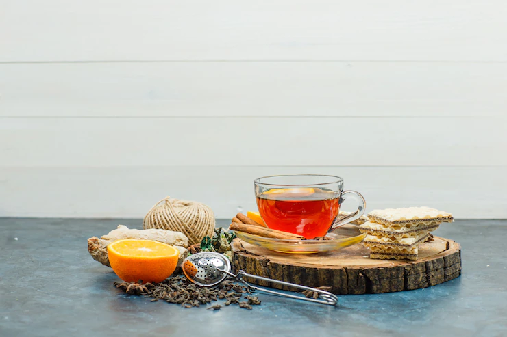 Tea Mug With Herbs Orange Spices Waffle Thread Wooden Board Strainer Side View White Stucco Background 176474 9846