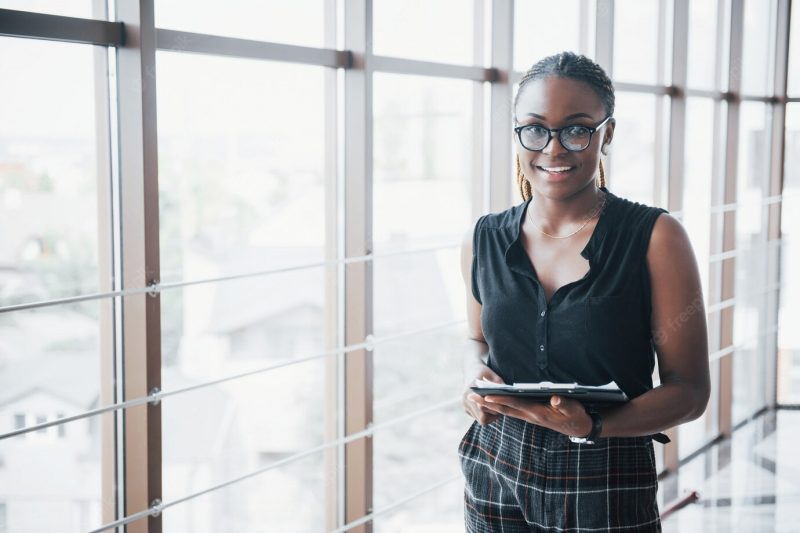 A thoughtful african american business woman wearing glasses holding documents Free Photo