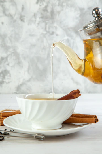 Top View Herbal Tea Pouring From Pot Into Cup White Background 140725 130483