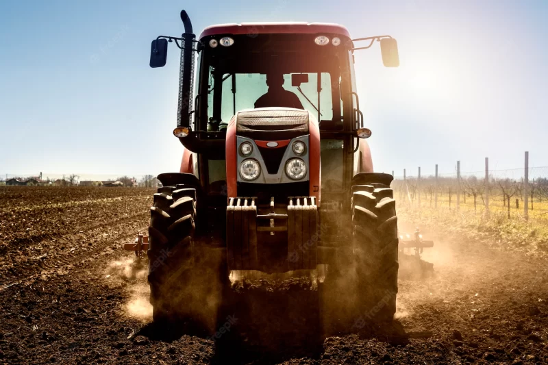 Tractor agricultural machine working in the field Free Photo