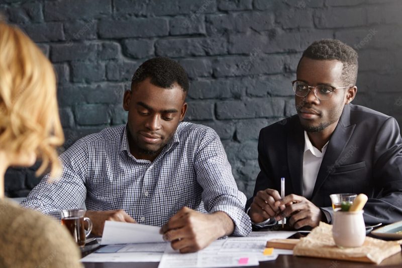 Two African recruiters interviewing unrecognizable woman candidate Free Photo