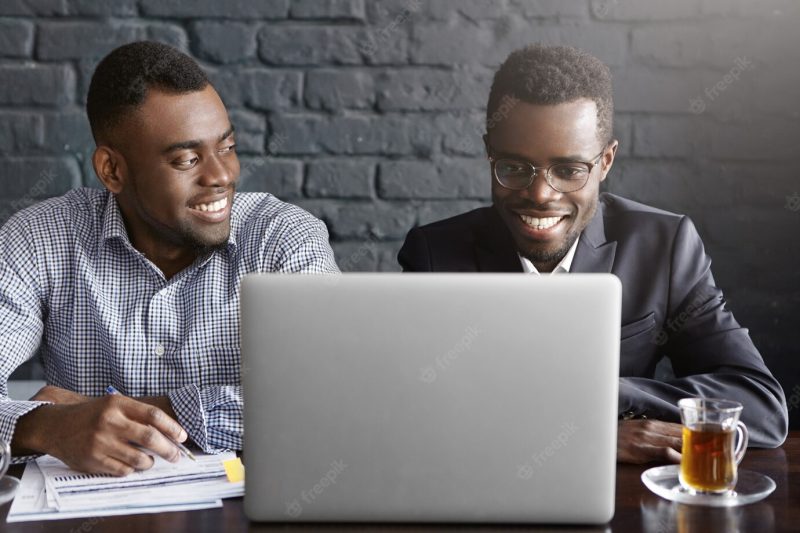 Two businessmen discussing financial data on digital tablet Free Photo