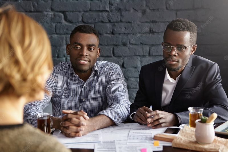Two confident and successful African hr managers interrogating young female candidate during job interview Free Photo Two confident and successful African hr managers interrogating young female candidate during job interview Free Photo