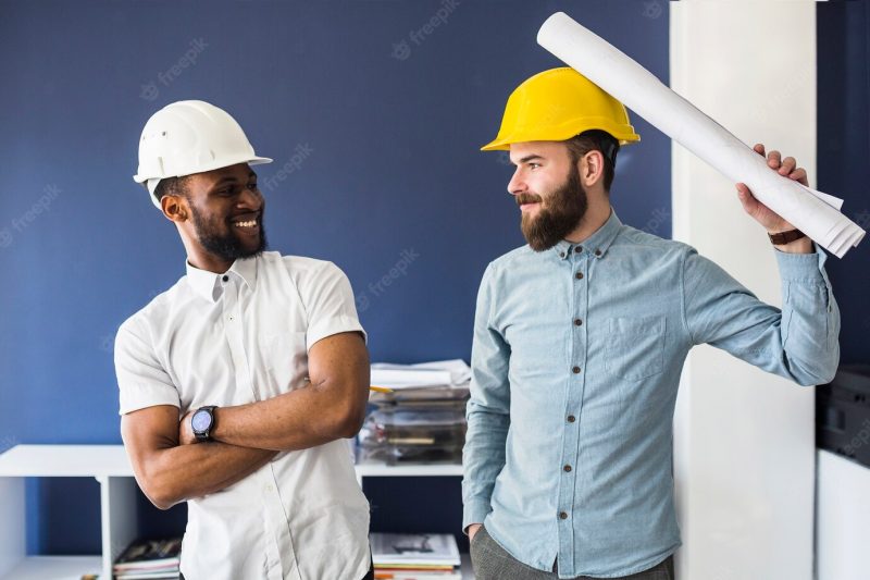 Two young male happy architects making fun in the office Free Photo