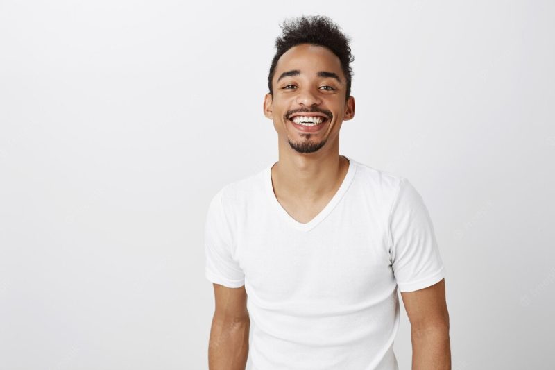 Waist-up of handsome smilingAfrican American man in white casual t-shirt looking happy Free Photo