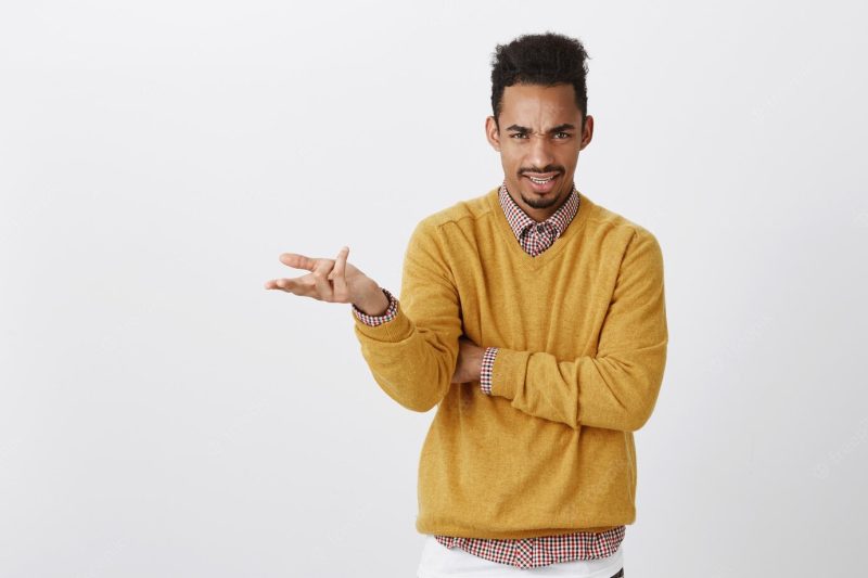 What do you want from me. portrait of outraged clueless young guy with afro haircut and stylish outfit raising palm and shrugging, frowning with displeased expression, being unaware, arguing Free Photo