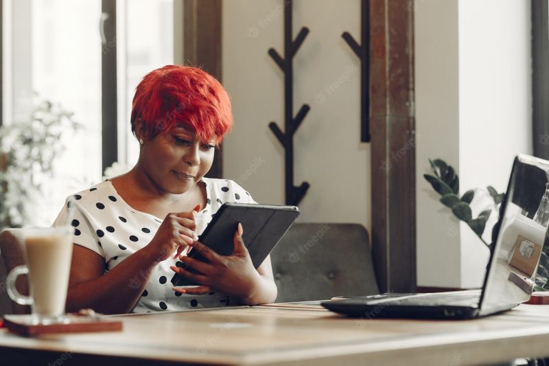 Young african american female working in an office. lady in a white blouse. Free Photo