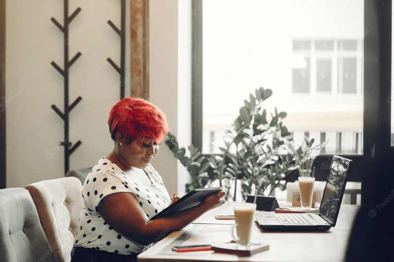 Young african american female working in an office. lady in a white blouse. Free Photo