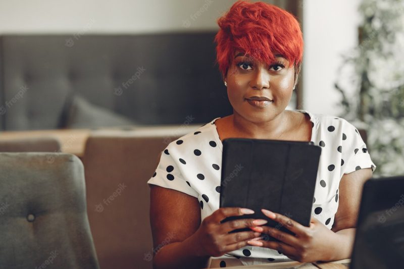 Young african american female working in an office. lady in a white blouse. Free Photo