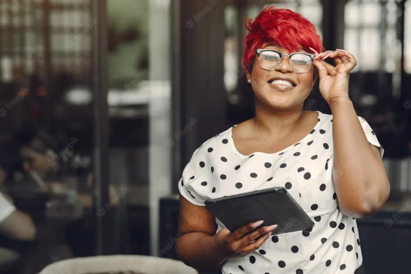 Young african american female working in an office. lady in a white blouse. Free Photo