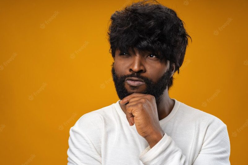 Young african american man thinking and touching his chin Free Photo